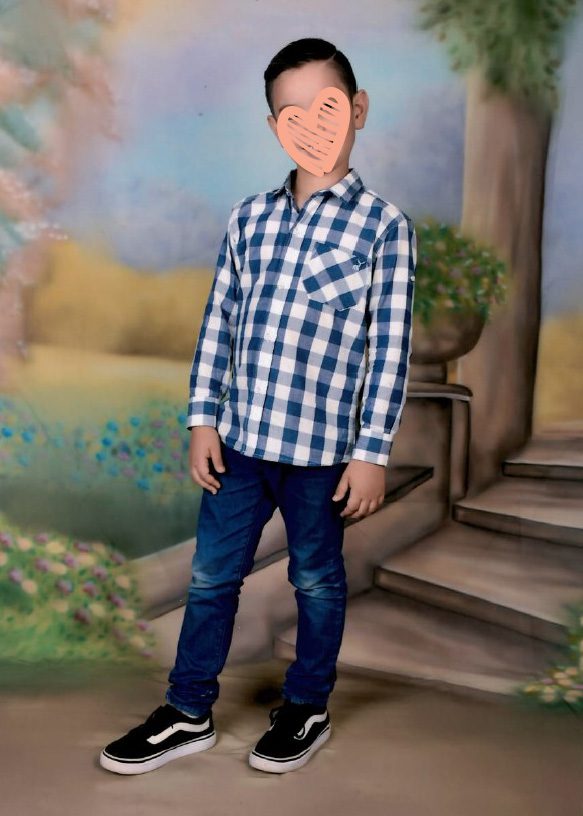 Boy in collared shirt standing and smiling