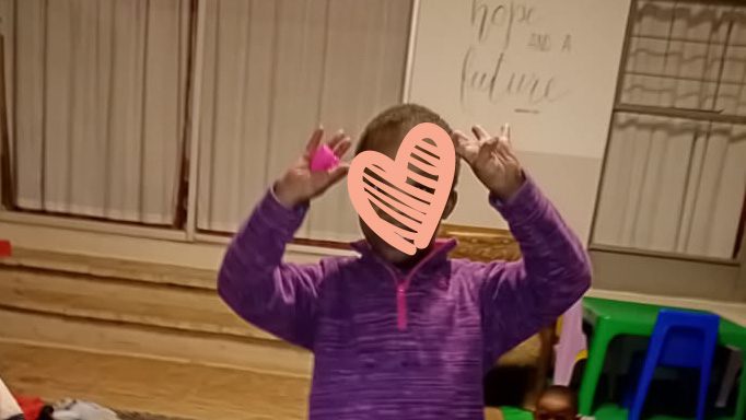 Little girl in purple sweater makes a funny face