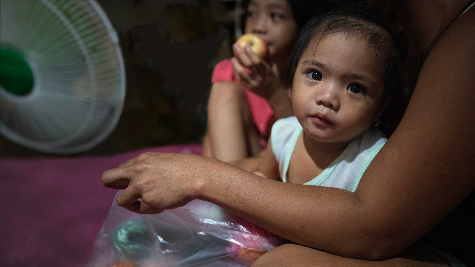 Philippines girl in mother's arms needing food