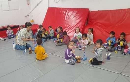 Group of kids in daycare play on colored mats