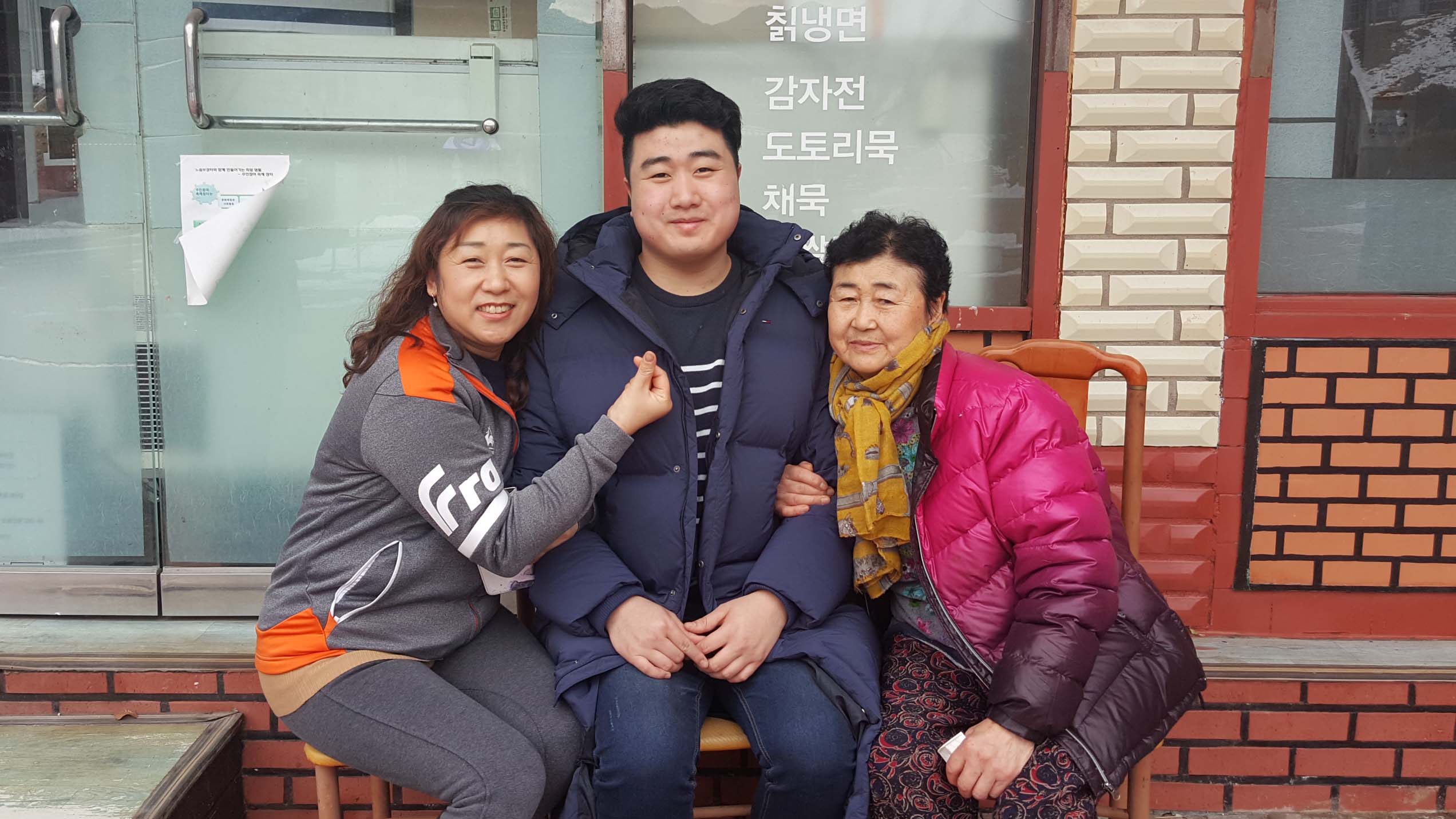 Young man sits with family members and smiles