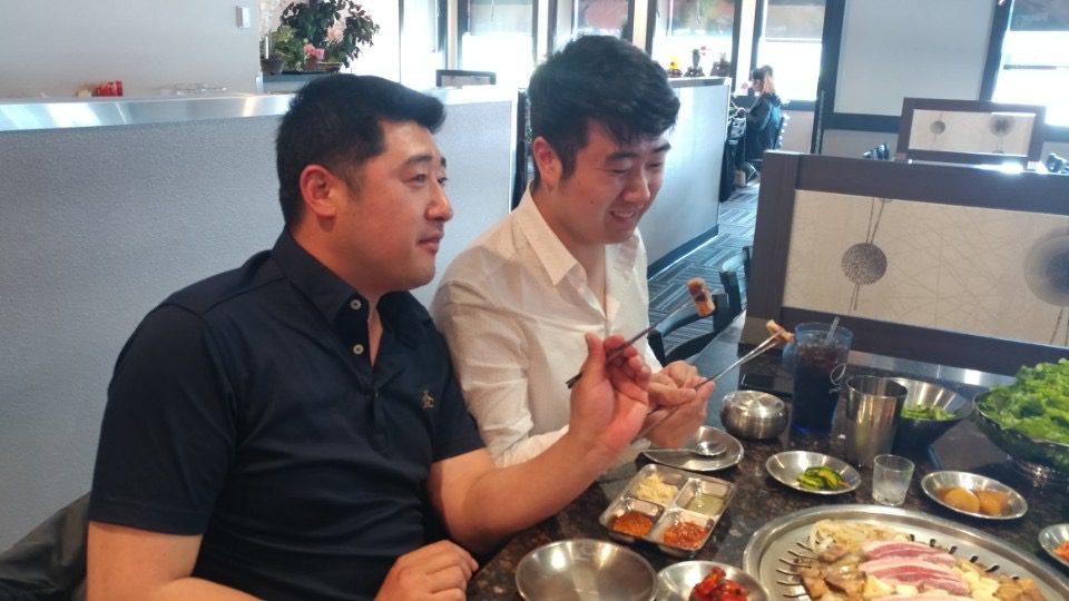 Father and son gather in a restaurant at dinner for Korean food