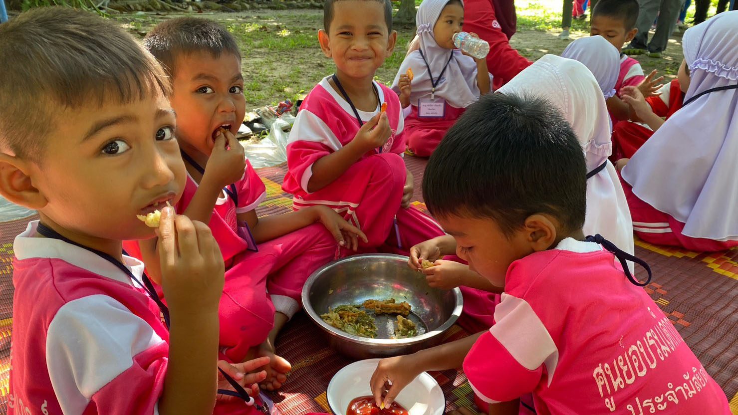 Group of little boys gathers eating tempura vegetables