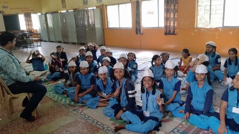 A group of students in blue uniforms smiles at camera