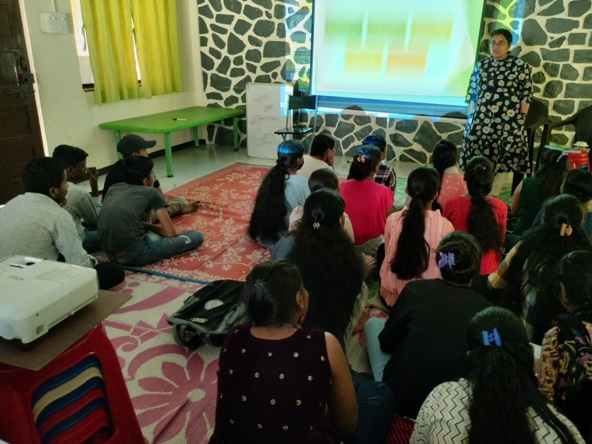 Group of students seated on floor pay attention to projected presentation