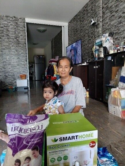 Grandmother and granddaughter pictures with family strengthening gift of rice cooker and rice
