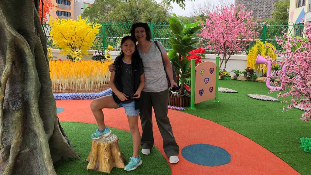 China adoptee girl with adoptive mom in colorful play garden while on Holt China tour