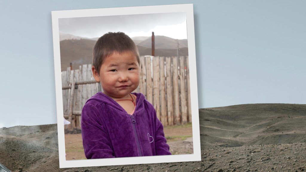 Little girl wearing a purple coat while standing in the cold in Mongolia.