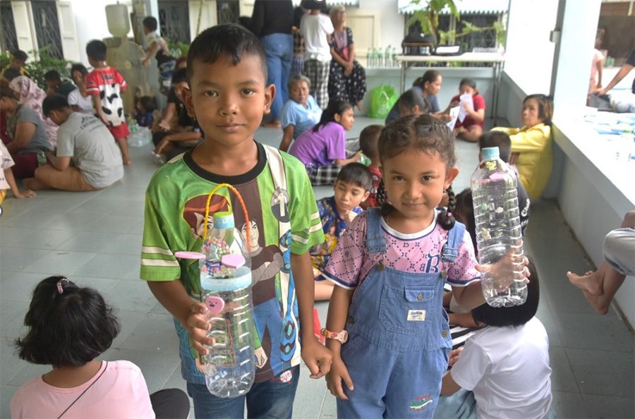 A little boy and a little girl hold up decorated water bottles