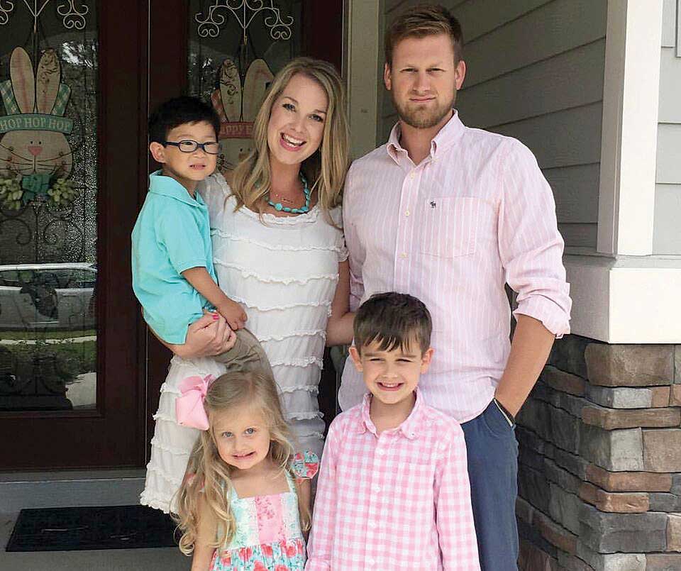 Blackshear family posing on front porch with their three children, including son adopted from Korea