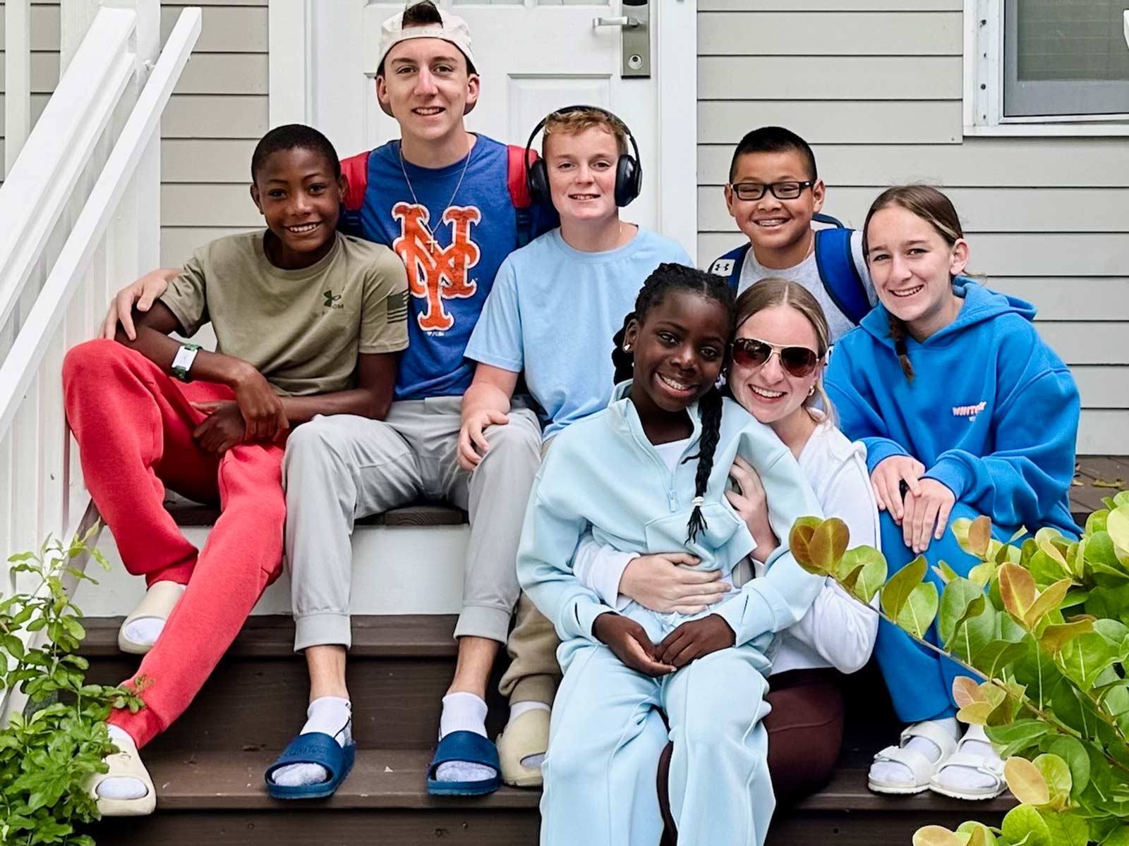 a group of siblings smiles all together with their adopted brother who recently came home