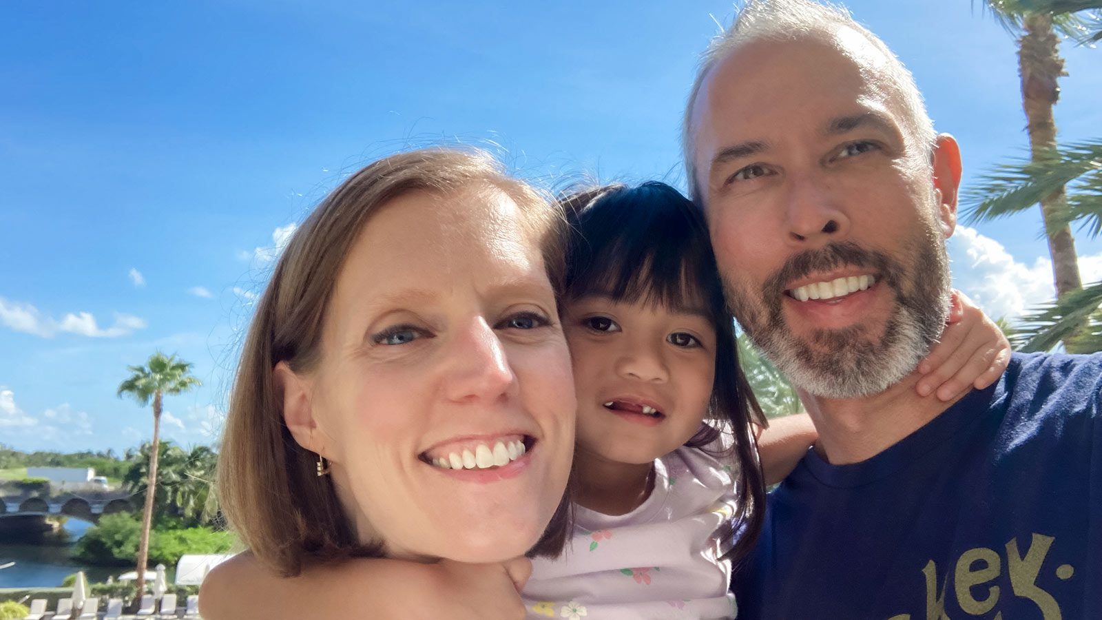 adoptive parents hug their adopted child